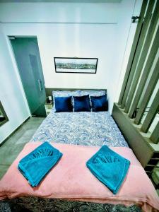 una camera da letto con un letto grande con cuscini blu di Loft Aconchego das Gerais Refúgio em São João del Rei a São João del Rei