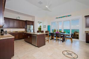 a kitchen and dining room with a table and chairs at Aqua Villa home in Governorʼs Harbour +22 photos