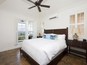 una camera da letto con un letto e un ventilatore a soffitto di French Leave South Beach Bight II Villa home a Governorʼs Harbour Altre 18 foto