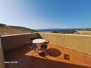 a table and chairs on a balcony with the ocean at Villa Diki beach in Ksar es Sghir