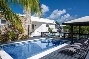 a villa with a swimming pool and a palm tree at Trident Estate estate in Palmetto Point +40 photos