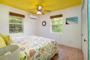 une chambre avec un lit et un ventilateur de plafond dans l'établissement Orchid Cottage cottage, à Governorʼs Harbour