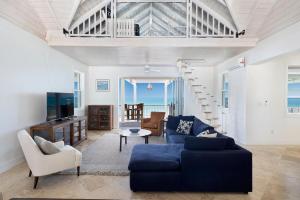 a living room with a blue couch and a tv at Buttonwood Reserve Main Lodge home in James Cistern