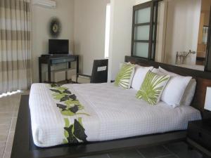 a bedroom with a large bed and a desk at Sky Beach Club Bungalow 2 cabin in Governorʼs Harbour