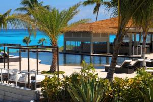 a resort with palm trees and a swimming pool at Sky Beach Club Bungalow 2 cabin in Governorʼs Harbour