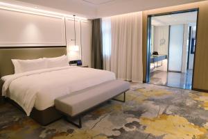 a bedroom with a large white bed and a hallway at Changyuan Xincheng International Hotel in Zhangzhai