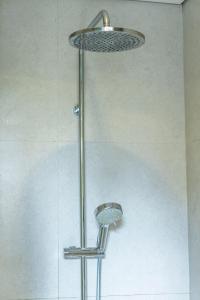 a shower with a metal shower head in a bathroom at Tulip Villa Ubud in Ubud +67 photos