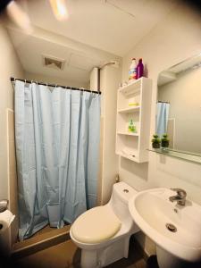une salle de bain avec toilettes et lavabo dans l'établissement Avida Towers Riala T3 Tunechi, à Cebu