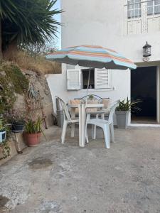 a table and chairs under an umbrella on a patio at Casa da Travessa in Alte