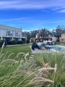 a view of a house and a swimming pool with grass at Mandalas Del Este in Piriápolis