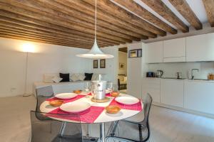 ein Esszimmer mit einem Tisch und Stühlen sowie eine Küche in der Unterkunft Ve.N.I.Ce. Cera Casa Del Giglio in Venedig