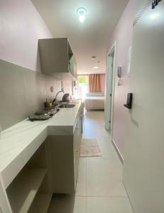 una cucina bianca con lavandino e una camera di Flat Beira-Mar Cabo Branco a João Pessoa