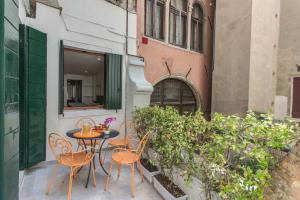 eine Terrasse mit einem Tisch und Stühlen auf dem Balkon in der Unterkunft Ve.N.I.Ce. Cera Casa Del Giglio in Venedig