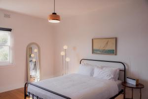 a bedroom with a bed with white sheets and a window at Trevallyn Retreat with River Views in Royal Park