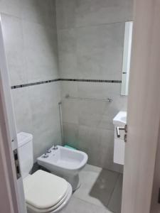 ein weißes Badezimmer mit Toilette und Waschbecken in der Unterkunft Armonia in Rosario