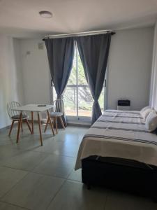 ein Schlafzimmer mit einem Bett und einem Tisch und Stühlen in der Unterkunft Armonia in Rosario