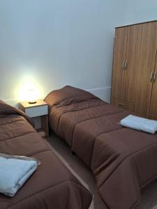 a bedroom with two beds and a night stand at BaireSuite 2 camas 2p Vista Parque! in Buenos Aires