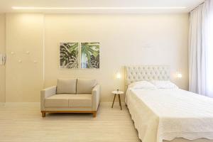 a bedroom with a bed and a chair at Studio no Coração de SP in Sao Paulo