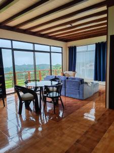 a living room with a couch and a table and chairs at Lodge Lake Arenal in Tilarán