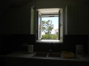 a kitchen counter with a sink and a window at Maira Arch House in Potamós +105 photos