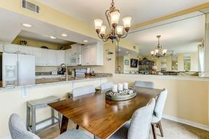 a kitchen and dining room with a wooden table and chairs at Oceans Of Amelia - 104 in Fernandina Beach +41 photos