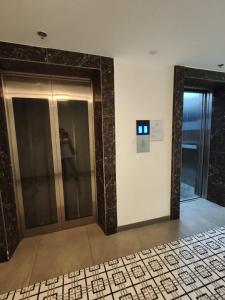 a elevator lobby with a glass door and a tile floor at Eya's Staycation in Baguio +2 photos