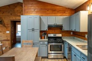 a kitchen with white cabinets and a stove top oven at Aska's Cozy Corner Cabin in Cherry Log