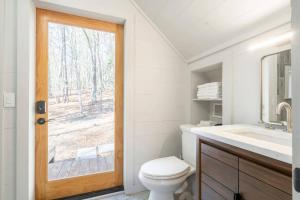 a bathroom with a toilet and a sink and a window at Aska's Cozy Corner Cabin in Cherry Log +19 photos
