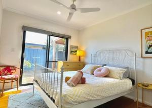 a bedroom with a white bed with pink pillows at Seascape - Kalbarri, WA in Kalbarri