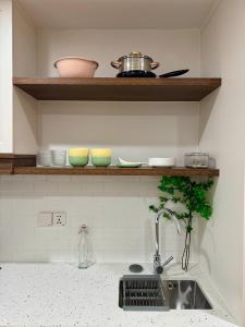 a kitchen counter with a sink and bowls on a shelf at Ly Lakeside House Tay Ho Ha Noi in Hanoi