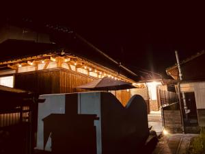 a building with an umbrella in front of it at night at 波止場の海まで徒歩30秒の宿ギョグンミニ"Gyogun Mini" in Ainan