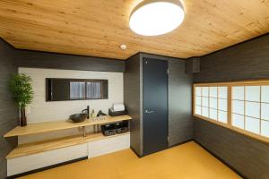 a kitchen with a black door and wooden ceiling at 金柑和屋 in Osaka