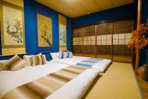 two beds in a room with blue walls at 金柑和屋 in Osaka