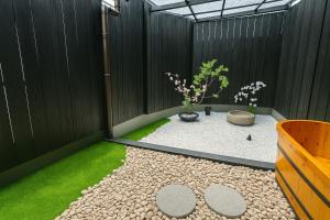 a small courtyard with a potted plant and grass at 金柑和屋 in Osaka