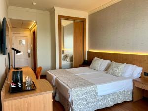 a hotel room with a large bed and a table at Hotel Santa Rosa in Torrox Costa