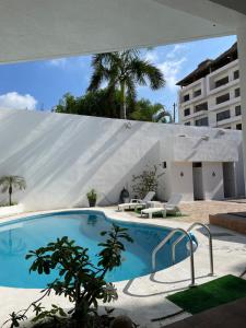 une grande piscine devant un immeuble dans l'établissement Casa Blanca, à Acapulco