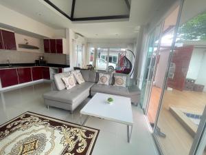 a living room with a couch and a table at The Sun Pool Villa in Chaweng