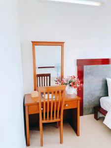 a room with a desk with a mirror and a table with flowers at Khách sạn HTC REGINA TUẦN CHÂU in Ha Long +33 photos