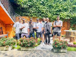 un groupe d'hommes posant une photo dans un jardin dans l'établissement Airport J Dream Resort, à Dewamottawa