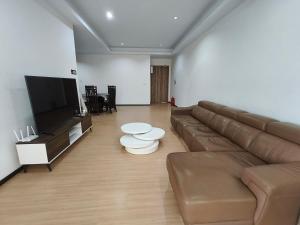 a living room with a couch and a flat screen tv at Vi Homelite Resort Airport in Miri