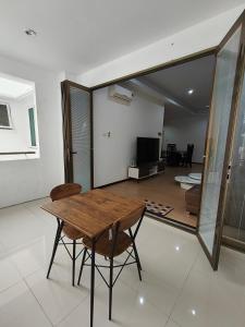 a living room with a wooden table and chairs at Vi Homelite Resort Airport in Miri