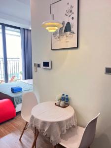 a room with a table and chairs and a bed at GreenBay- G34030 in Hanoi