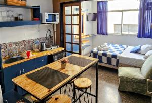 a small room with a kitchen and a bed and a table at Microstudio & Parking in Mendoza