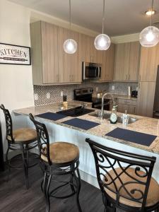 a kitchen with a counter with chairs and a sink at North Texas vacation get away! in The Colony