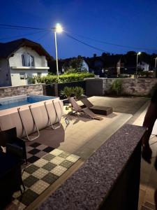 a swimming pool with lounge chairs and a house at Una Bihac 4 in Bihać