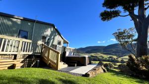a house with a staircase leading up to a porch at Mohua Park - Catlins Eco Accommodation in Owaka
