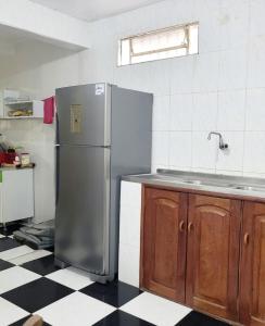 eine Küche mit einem Kühlschrank aus Edelstahl und einem karierten Boden in der Unterkunft Hospedagem aconchegante - COP 30 - Belém in Belém
