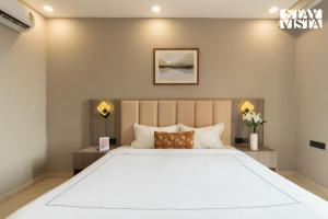 a bedroom with a large white bed with two lamps at StayVista Residences near Cyber City Hub with Gym & Air Purifier in Gurgaon