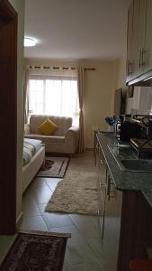 a kitchen and living room with a couch and a table at Nairobi West Studio apartment close to town in Nairobi