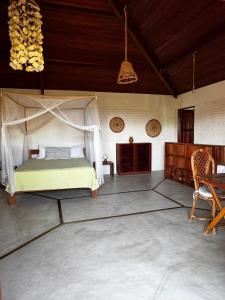 a bedroom with a canopy bed and a table and chairs at Casa Bem Te Vi in Icaraí